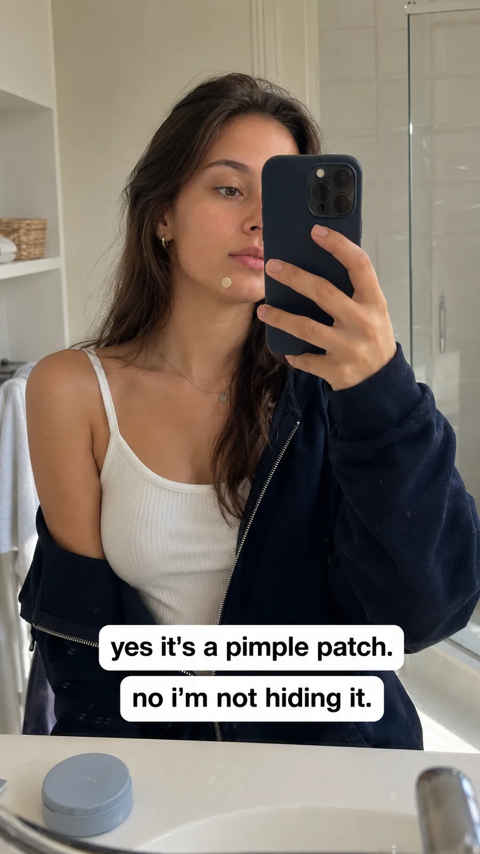 Vael — a real mirror selfie mid-morning-routine, patch worn on the cheek, 'yes it's a pimple patch. no i'm not hiding it.'